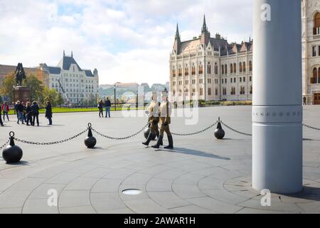 Bewaffnete, uniformierte Wachen marschieren vor oder das ungarische Parlamentsgebäude in Budapest, Ungarn Stockfoto