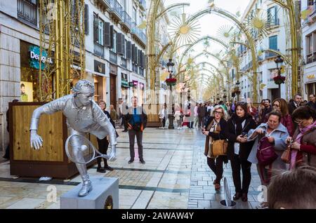 Málaga, Spanien: Die Menschen sehen sich eine lebende Statue an, die einen Tennisspieler auf der Straße Larios darstellt. Stockfoto