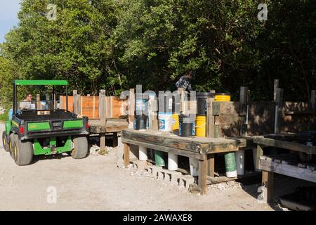 Ein John Deere Gator Utility Vehicle wird neben dem Oyster Reef Reef Restoration am Florida Oceanographic Coastal Center in Stuart, Florida, geparkt. Stockfoto