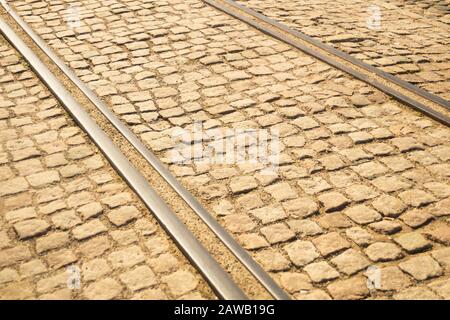 Ziegelstruktur: Tramschienen auf steinernem Straßenbelag Stockfoto