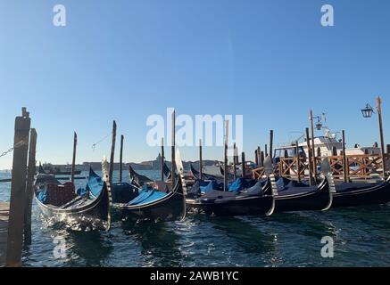 Venedig, Italien. Februar 2020. Leere Gondeln vor dem Markusplatz in Venedig. Drei Monate nach der dramatischen Überschwemmung passiert etwas seltsames. Venedig beklagt sich plötzlich über zu wenige Besucher. (Zu dpa-Korr 'Silence on St Mark's Square') Credit: Annette Reuther / dpa / Alamy Live News Stockfoto