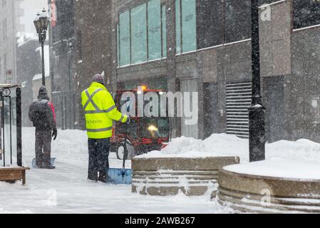 Montreal Quebec Kanada 6. Februar 2020: Stadtarbeiter beobachten einen kleinen Schneepflug während eines Schneesturms Stockfoto