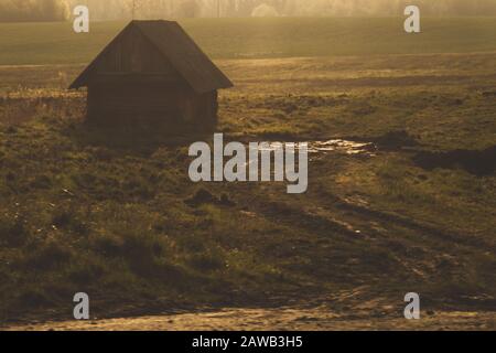 Altes Holzhaus auf dem Land, Haus steht allein unter dem Feld Stockfoto