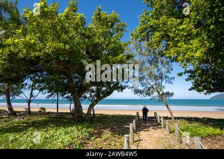 Blick auf den Fußweg zum von Bäumen gesäumten Mission Beach an der Coral Sea, Far North Queensland, Australien Stockfoto