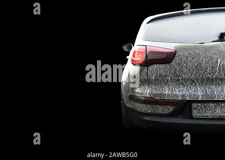 Rückansicht eines sehr schmutzigen Autos isoliert auf schwarzem Hintergrund. Fragment eines schmutzigen SUV. Verschmutzte Scheinwerfer, Rad und Stoßstange des Geländewagens mit Sumpf Stockfoto