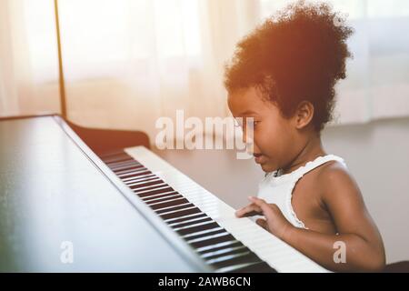 Kinder Mädchen, die Klavier spielen, sehen aufregend glücklich aus und genießen mit Musikinstrument und seien Sie Spieler Stockfoto