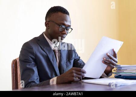 Afrikanischer Ethnie cleverer Mann bei Arbeitschef beschäftigt Stockfoto