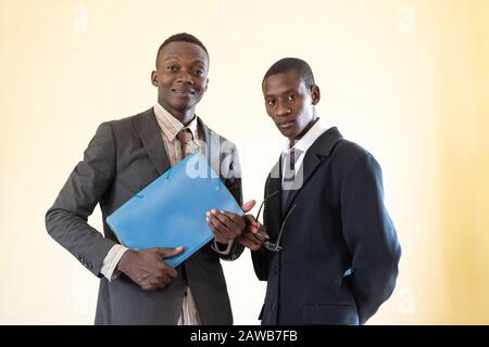 Afrikanische ethnische Person, die sich selbst erzieht, in Anzug und Krawatte ernsthaft zu sehen Stockfoto