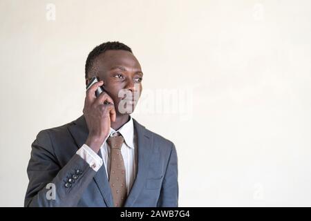 Ein gutaussehender afrikanischer Geschäftsmann, Der am Telefon Geschäfte macht Stockfoto