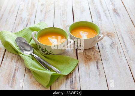 Püree Suppe aus orangefarbenem Kürbis, Süßkartoffeln und Karotten, serviert mit saurer Sahne Stockfoto