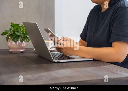 Nahaufnahme der Frau mit Smartphone und Laptop Stockfoto