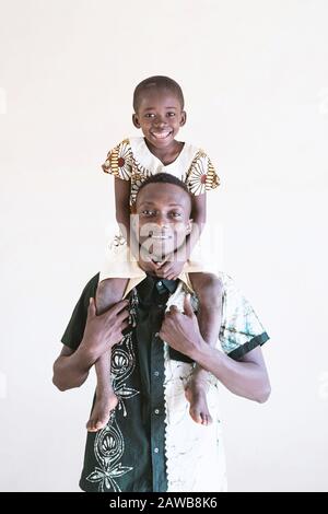 Afrikanischer Junge und Vater posieren vor der Kamera und haben Spaß am Smiling und beim gemeinsamen Lachen Stockfoto