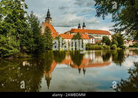 TelC/Tschechien - 27. September 2019: Blick auf die Burg, den Turm der Jakobskirche die Großen und historischen Häuser über einem See. Stockfoto