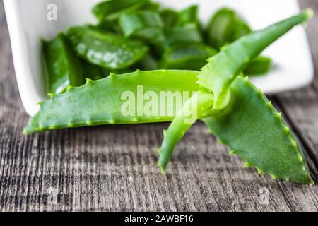 Slices of Aloe vera in einer Schüssel auf einem Holztisch. Aloe Vera zur Behandlung und Hautpflege. Stockfoto