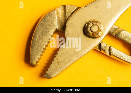 Rohrschlüssel auf gelbem Hintergrund. Verstellbarer Gasschlüssel. Gerät zur Reparatur. Arbeitswerkzeug Stockfoto