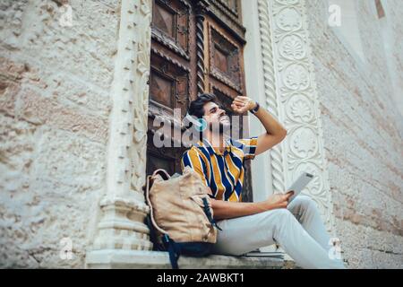 Junge, gutaussehige Tourist Männer, die digitale Tablets in einer Stadt verwenden. Stockfoto