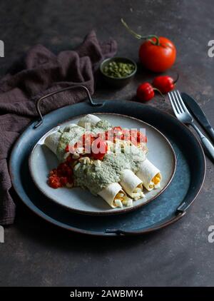 Mexikanische Küche - Papadzules traditionelles Gericht von der Yucatan-Halbinsel - Maistortillas, die in eine Sauce von Kürbissamen getaucht sind, die mit gekochten Eiern gefüllt sind, Stockfoto