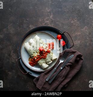 Mexikanische Küche - Papadzules traditionelles Gericht von der Yucatan-Halbinsel - Maistortillas, die in eine Sauce von Kürbissamen getaucht sind, die mit gekochten Eiern gefüllt sind, Stockfoto