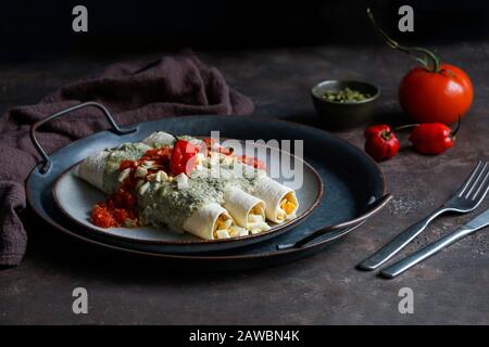 Mexikanische Küche - Papadzules traditionelles Gericht von der Yucatan-Halbinsel - Maistortillas, die in eine Sauce von Kürbissamen getaucht sind, die mit gekochten Eiern gefüllt sind, Stockfoto