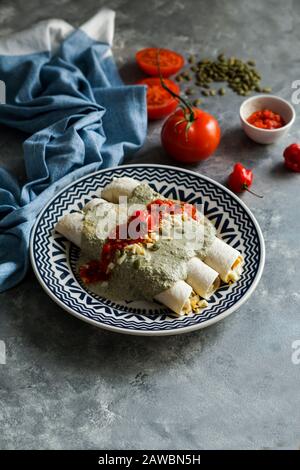 Mexikanische Küche - Papadzules traditionelles Gericht von der Yucatan-Halbinsel - Maistortillas, die in eine Sauce von Kürbissamen getaucht sind, die mit gekochten Eiern gefüllt sind, Stockfoto