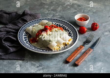 Mexikanische Küche - Papadzules traditionelles Gericht von der Yucatan-Halbinsel - Maistortillas, die in eine Sauce von Kürbissamen getaucht sind, die mit gekochten Eiern gefüllt sind, Stockfoto