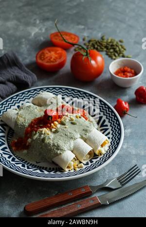 Mexikanische Küche - Papadzules traditionelles Gericht von der Yucatan-Halbinsel - Maistortillas, die in eine Sauce von Kürbissamen getaucht sind, die mit gekochten Eiern gefüllt sind, Stockfoto