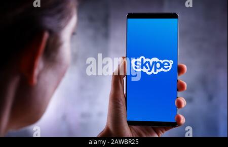 Poznan, POL - Jul 10, 2019: Frau mit Smartphone mit Skype-Logo, Anwendung, die sich auf die Bereitstellung von Video-Chat und Sprachanrufen spezialisiert hat Stockfoto