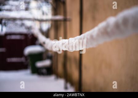 Drahtzaun und metallisches Netz mit Schnee. Metallnetz im Winter mit Schnee bedeckt. Stockfoto