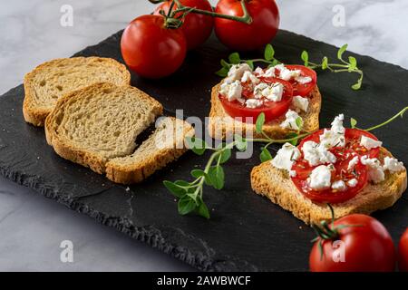 Kleine Toasts mit Tomaten und Fetakäse. Stockfoto
