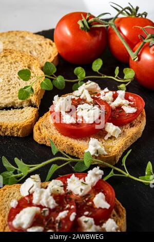 Kleine Toasts mit Tomaten und Fetakäse. Stockfoto