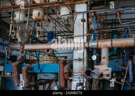 Alte rostige Industrietanks, die durch Rohre mit Ventilen verbunden sind. Stockfoto