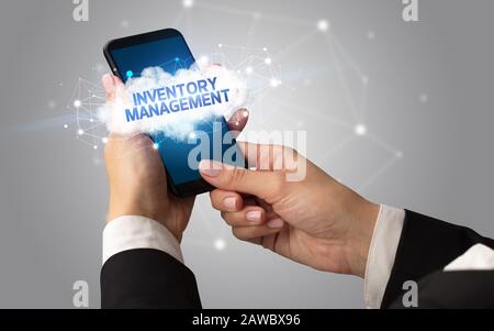 Weibliche Hand berühren Smartphone mit Inventory Management Inschrift, Cloud Business Konzept Stockfoto