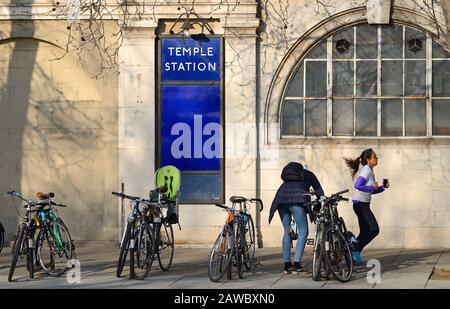 London, England, Großbritannien. U-Bahnhof Temple auf der Victoria-Embankment - Frau, die mit einem Handy läuft Stockfoto