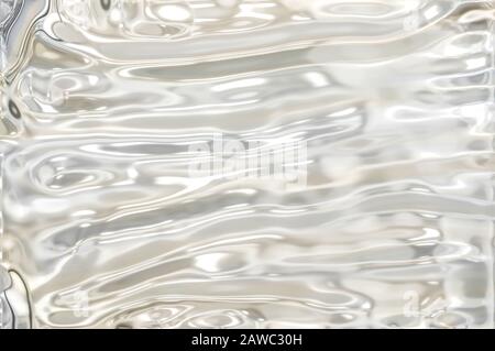 Metallisch silberfarbener Wellenhintergrund. Silberfarbene Folientextur, grau metallisch glänzende Textur. Stockfoto