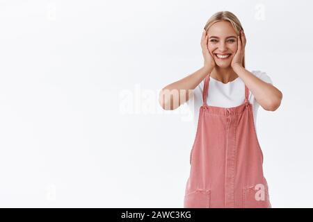 Mädchen sehr glücklich verliebt, Schmetterlinge im Magen spüren, Wangen drücken und von Glück und Jubel erröten, im stehen entzückt schauen Stockfoto