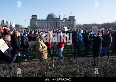 Berlin, Deutschland. Februar 2020. Demonstranten stehen während einer Aktion gegen die Rechten und die Vorfälle in Thüringen mit Zeichen und Fahnen auf dem Reichstag. Credit: Paul Zinken / dpa / Alamy Live News Stockfoto