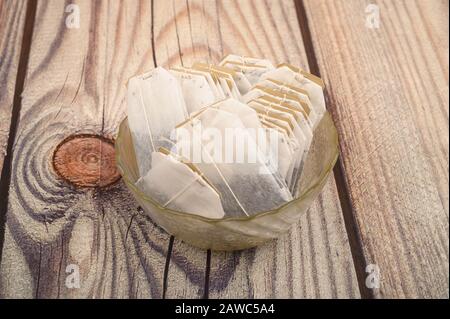 Teebeutel in einer Glasvase auf Holzhintergrund. Nahaufnahme Stockfoto