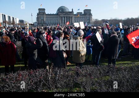 Berlin, Deutschland. Februar 2020. Demonstranten stehen während einer Aktion gegen die Rechten und die Vorfälle in Thüringen mit Zeichen und Fahnen auf dem Reichstag. Credit: Paul Zinken / dpa / Alamy Live News Stockfoto