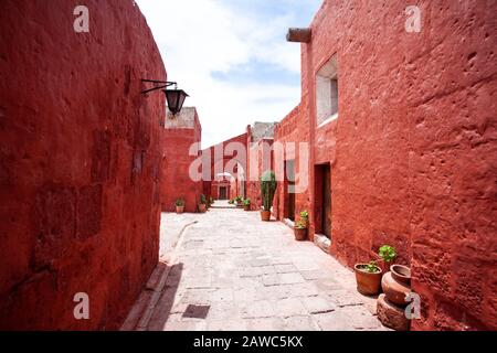 Bögen auf den Straßen im Kloster Santa Catalina, Arequipa, Peru, große Kakteen und Geranien in Töpfen. Stockfoto