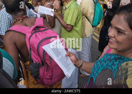 Während des Hindu-Festivals in Thaipusam singt eine Teilnehmerin tamilische Gebete und liest ein tamilisches Gebetbuch vor; Little India, Singapur Stockfoto