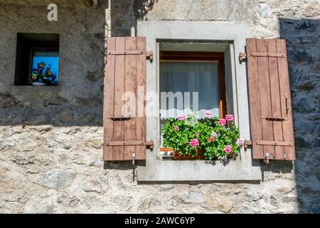 Kleine und große Fenster an der Steinmauer Stockfoto