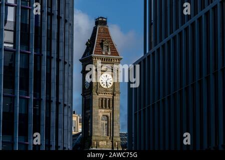 Alter Uhrturm zwischen Glasneubauten Stockfoto