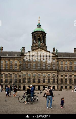 Anzeigen von Personen, die an der Dam Platz in Amsterdam hängen. Royal Palace ist im Hintergrund. Stockfoto