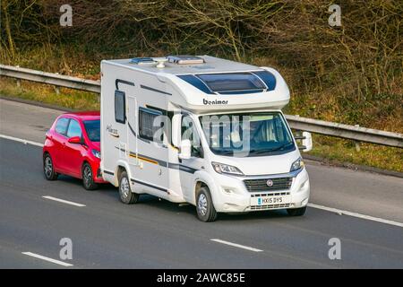 2015 weiß Benimar Mileo 202 Wohnmobil Wohnwagen Auto-Sleeper, Schleppen kleiner Kompaktwagen auf der M61; Manchester, UK Stockfoto