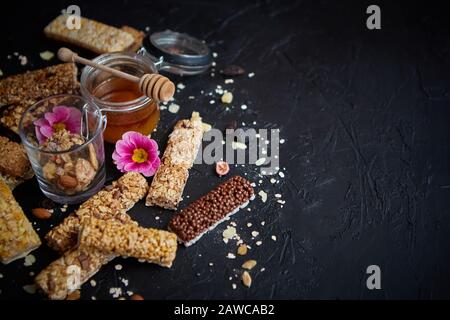 Gesunde Superfood-Zusammensetzung. Verschiedene Arten von Granola-Energie-Proteinbars mit Honig im Glas Stockfoto