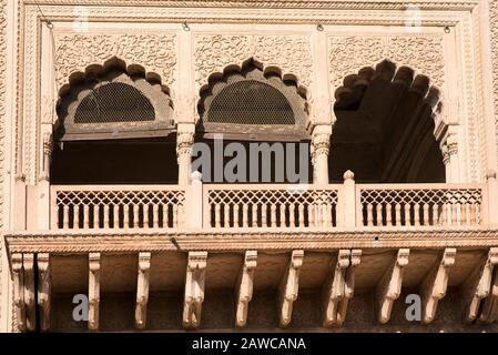 Außenansicht eines kunstvoll geschnitzten Fensters und Balkon auf einem alten Tempel in Vrindavan, einer heiligen Stadt in Mathura, Uttar Pradesh, Indien, Asien. Stockfoto