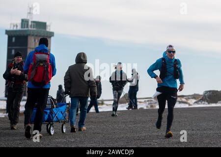 08. Februar 2020, Sachsen-Anhalt, Wernigerode: OLE Evers (r.) erreicht den Harzgipfel während der "Brocken-Challenge" als Harzgipfel. Der Extremsportler erreichte den Brocken bei trockenem Wetter, Wind und kühlen Temperaturen als Zweiter. Der 80 Kilometer lange Benefiz-Ultramarathonlauf wird jährlich vom Verein "Ausdauersport für Menschlichkeit" veranstaltet und fand zum 17. Mal statt. Rund 180 Läufer starteten am Morgen um 06:00 Uhr in Göttingen. Das Wetter im Harz dürfte sich in den kommenden Tagen grundlegend ändern. In der Nacht zum Montag erreicht ein Sturmtief die Region. Dann Stockfoto