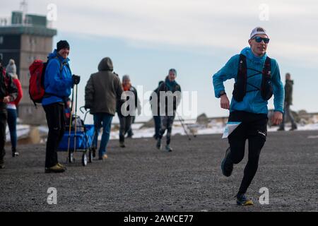 08. Februar 2020, Sachsen-Anhalt, Wernigerode: OLE Evers (r.) erreicht den Harzgipfel während der "Brocken-Challenge" als Harzgipfel. Der Extremsportler erreichte den Brocken bei trockenem Wetter, Wind und kühlen Temperaturen als Zweiter. Der 80 Kilometer lange Benefiz-Ultramarathonlauf wird jährlich vom Verein "Ausdauersport für Menschlichkeit" veranstaltet und fand zum 17. Mal statt. Rund 180 Läufer starteten am Morgen um 06:00 Uhr in Göttingen. Das Wetter im Harz dürfte sich in den kommenden Tagen grundlegend ändern. In der Nacht zum Montag erreicht ein Sturmtief die Region. Dann Stockfoto