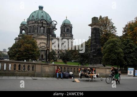 Ein Straßenhändler mit seinem ostdeutschen und russischen Militär-Souvenirstall in der Nähe des Berliner Doms am Spreeufer Stockfoto