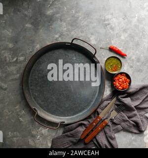 Kolumbianische Küche, aji picante, hogao salsa, auf der Metallschale und Zutaten für Souce, auf der grauen Betonkulisse, Platz für Designtext Stockfoto